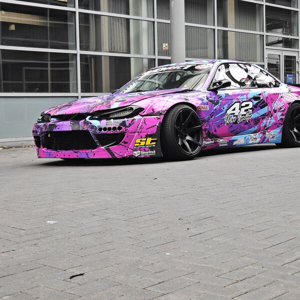 Nissan 200SX S14.9 „The Queen“ in Dreiviertel-Ansicht vor einer Glasfassade