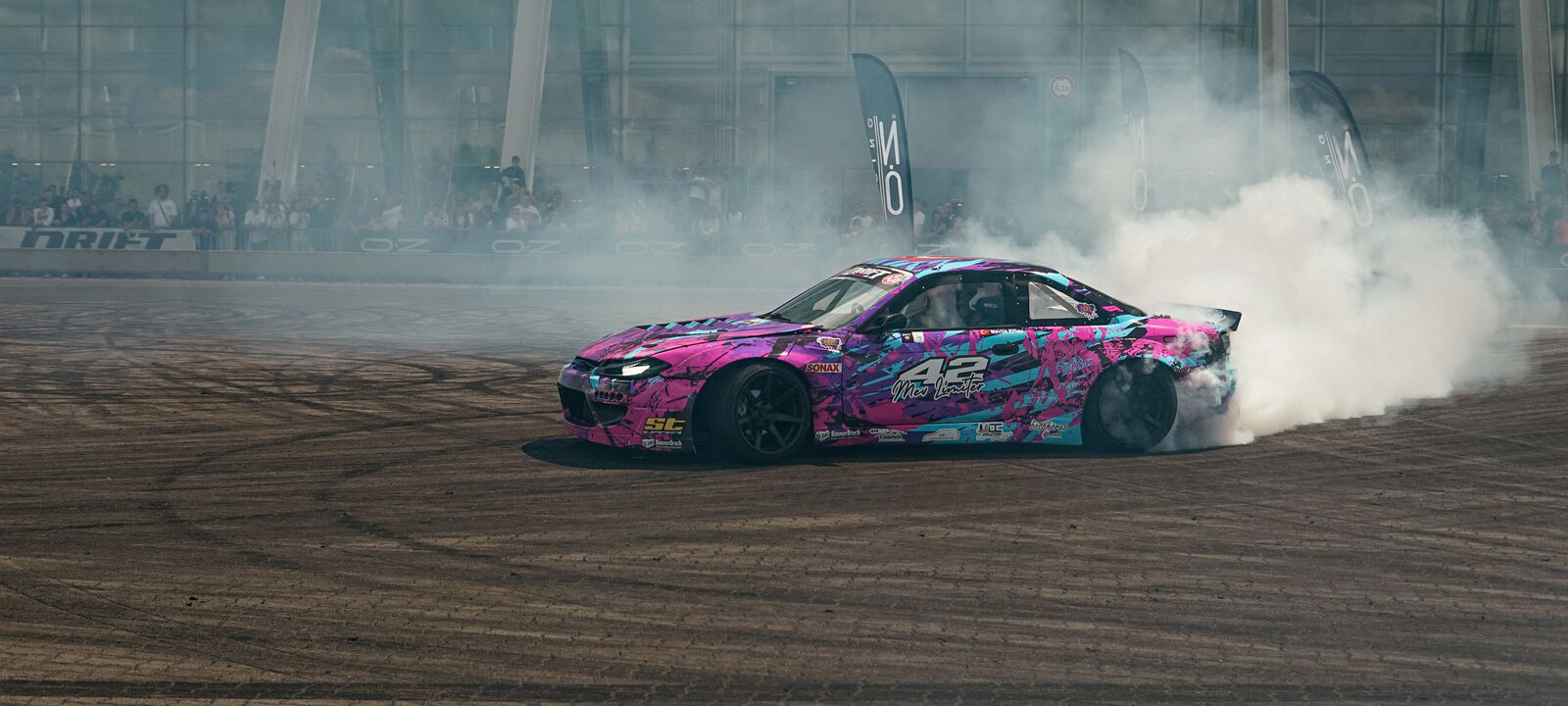Pinke S14.9 mit Startnummer 42 dreht Donuts im dichten Reifenrauch vor Publikum