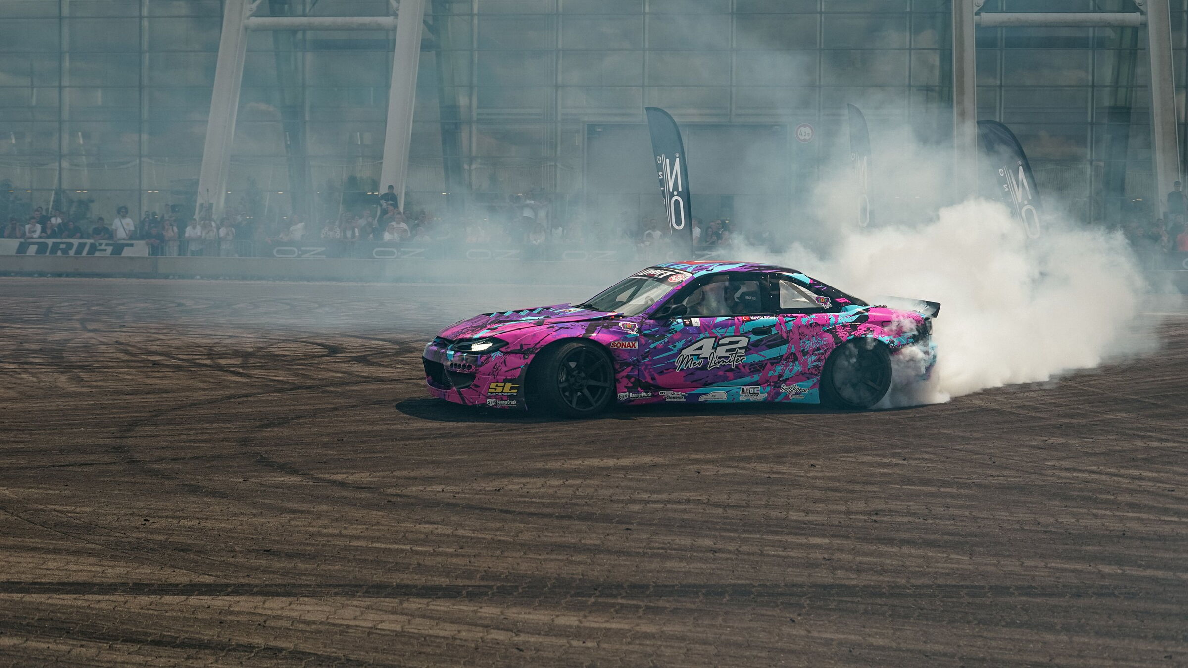 Pinke S14.9 mit Startnummer 42 dreht Donuts im dichten Reifenrauch vor Publikum