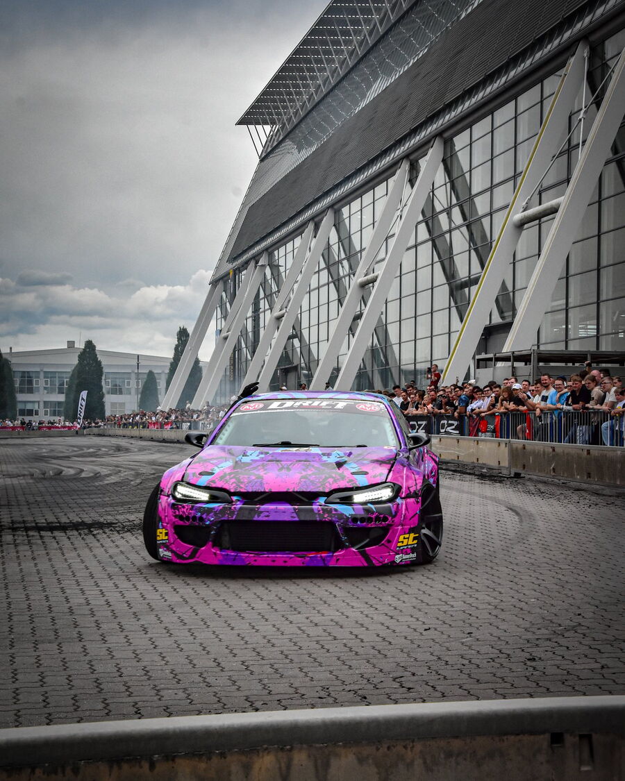 Die pinke S14.9 von vorn im Hochformat, dahinter das Expo-Dach in Hannover